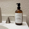 Amber glass refillable 16 oz Boston round pump bottle for lotion with black metal pump.