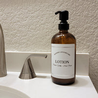 Amber glass refillable 16 oz Boston round pump bottle for lotion with black metal pump.