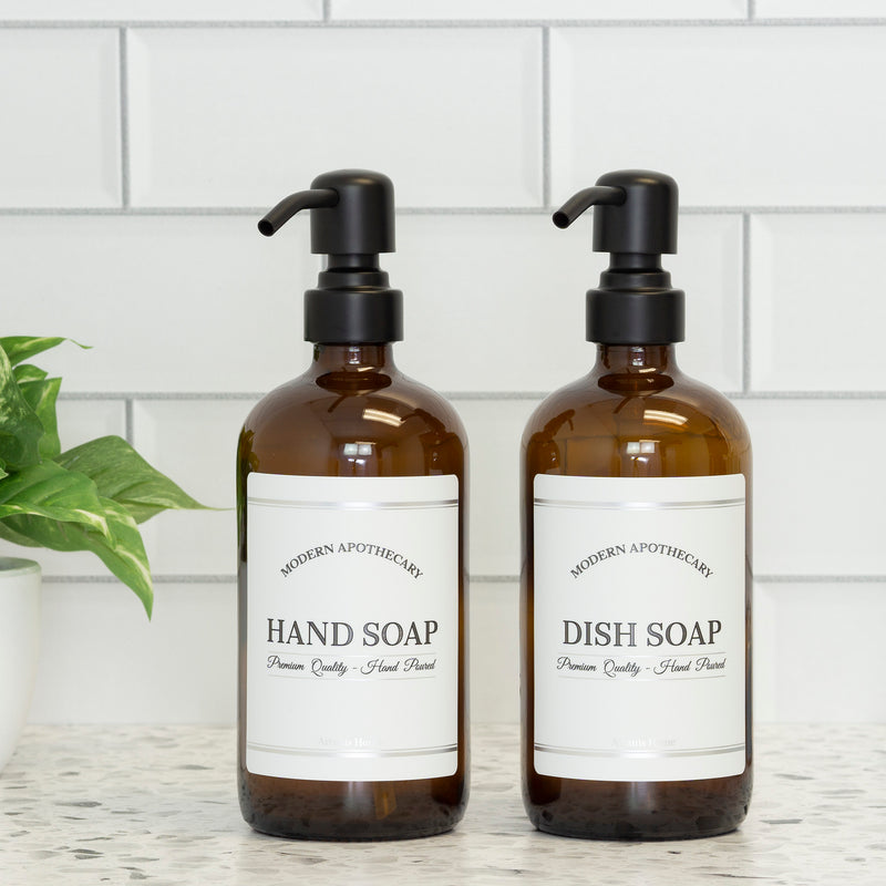 Amber glass 16oz Boston round bottles with Modern Apothecary labels for hand soap and dish soap with 304 grade black steel pumps. 