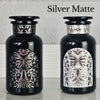 Two Miron violetglass apothecary jars with butterfly labels in white and black.